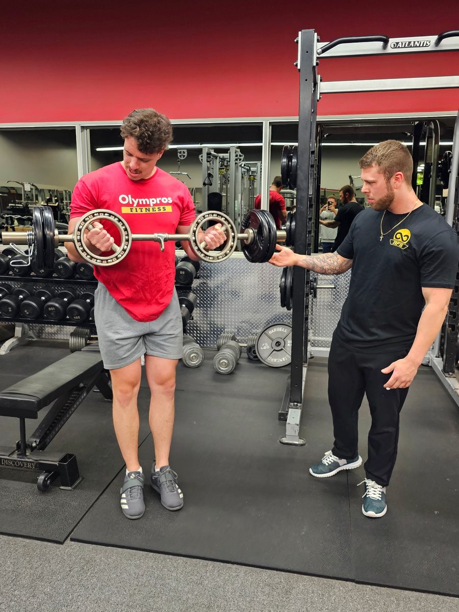 Samuel en train de coacher un client au gym pendant un exercice de musculation